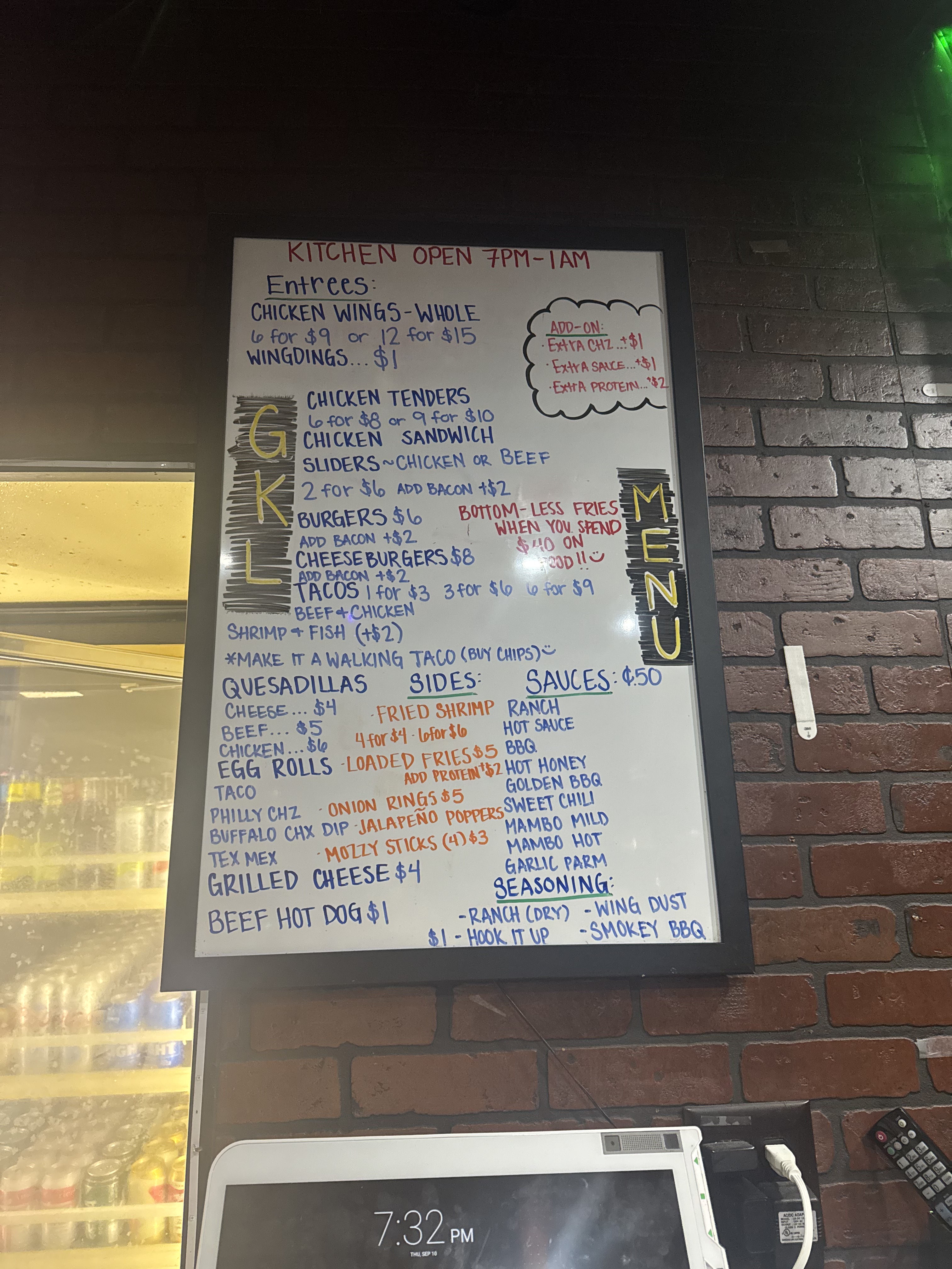 GKL Bar & Grill handwritten menu board with entrees, sides, sauces and prices